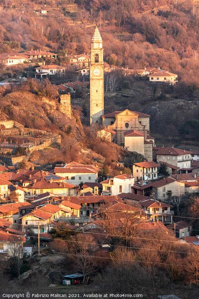 Afternoon sunlight over the village town and churc Picture Board by Fabrizio Malisan