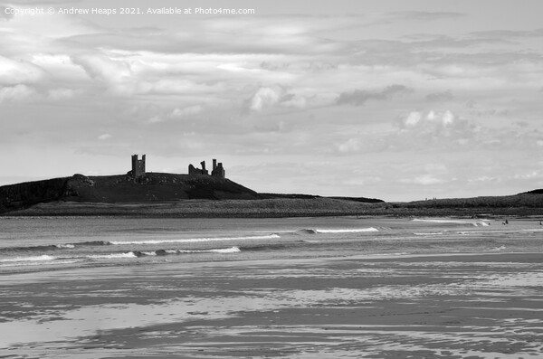 Dunstanburgh castle with waves viewed from beach. Picture Board by Andrew Heaps