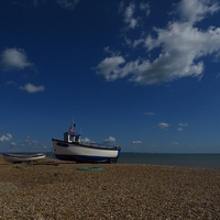 Buy canvas prints of  Shingle, Boats and Puffy White Clouds by Andrew Wright