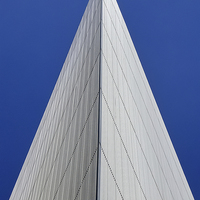 Buy canvas prints of An angular building pierces a blue sky  by Jamie Lumley