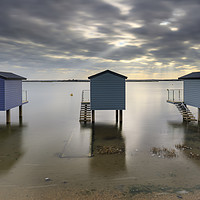 Buy canvas prints of Shafts of light over Osea Beach Huts by Andrew Ray