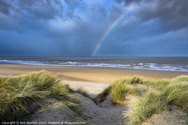 Rainbow over Holkham Bay Dunes. Picture Board by Rick Bowden