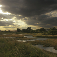 Buy canvas prints of The sun breaks through over the winter saltmarsh by James Tully