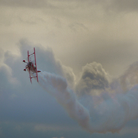 Buy canvas prints of A smoking biplane corksrews in heavy cloud  by James Tully