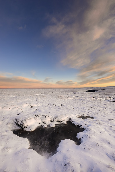 Icy pool on the snowy moors at dusk Picture Board by Andrew Kearton