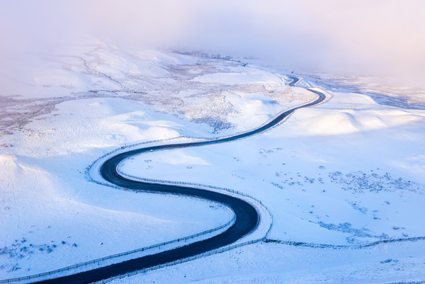 Bendy road through the snow Picture Board by Andrew Kearton