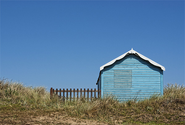Blue beach hut on a hill Picture Board by John Edwards