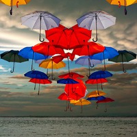 Buy canvas prints of colorful umbrellas against a stormy sky by ken biggs