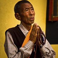 Buy canvas prints of Elderly Tibetan man, Boudhanath Temple, Kathmandu, by Julian Bound