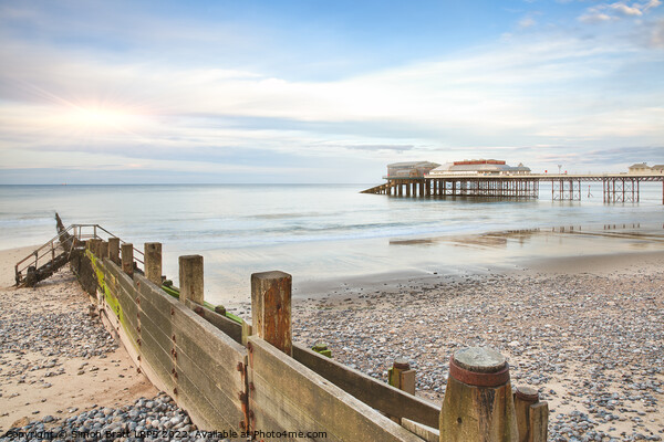 Cromer Pier in Norfolk England with beach groin Picture Board by Simon Bratt LRPS