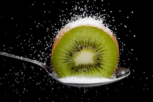 Kiwi fruit cut in half on a spoon with sugar Picture Board by Simon Bratt LRPS