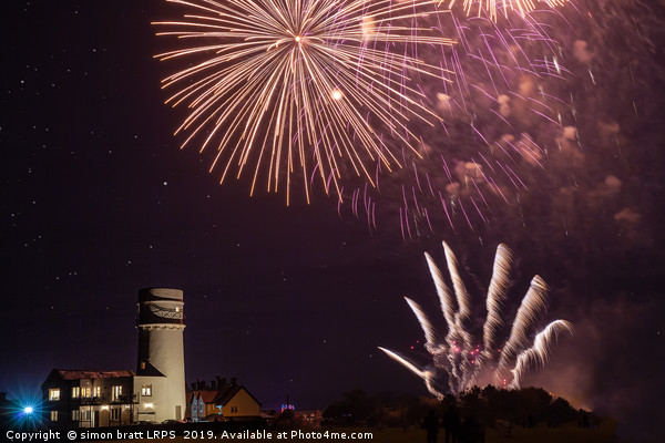Bonfire night foreworks over lighthouse in Norfolk Picture Board by Simon Bratt LRPS
