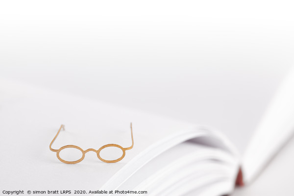 Tiny reading glasses on open book Picture Board by Simon Bratt LRPS