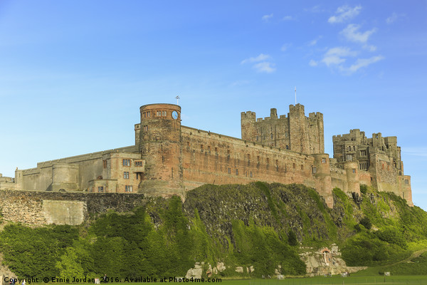 Bamburgh Castle on a August day. Picture Board by Ernie Jordan