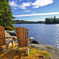 Buy canvas prints of Adirondack chairs at lake shore by ELENA ELISSEEVA