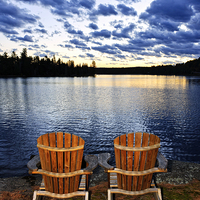 Buy canvas prints of Wooden chairs at sunset on lake shore by ELENA ELISSEEVA