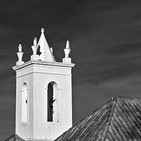 Buy canvas prints of Church bell tower behind tiled roofs in Tavira by Angelo DeVal