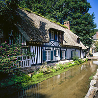 Buy canvas prints of   Half timber frame house with stream Normandy Fra by Philip Enticknap