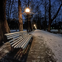 Buy canvas prints of Bench In The Dark Park by Jukka Heinovirta