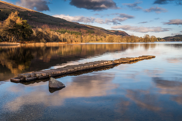 The old stone jetty on the shore of a very still L Picture Board by George Robertson