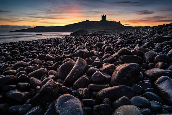 First light on the rocks at Dunstanburgh Castle Picture Board by George Robertson