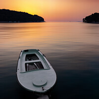 Buy canvas prints of Fishing boat in a sea, near coast. Sunset time. by Sergey Fedoskin