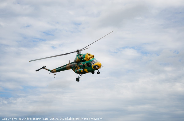Khaki colored helicopter is flying in sky Picture Board by Andrei Bortnikau