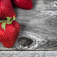 Buy canvas prints of Close up of fresh strawberry fruit on rustic wood by Thomas Baker