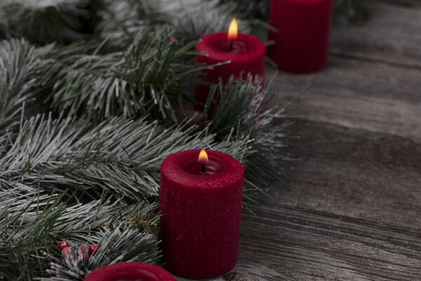 Red glowing candles with fir and wood dark background  Picture Board by Thomas Baker