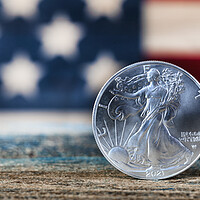 Buy canvas prints of American silver eagle dollar coin with US flag in background by Thomas Baker