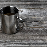 Buy canvas prints of Dark coffee inside stainless steel mug on old wood table with co by Thomas Baker