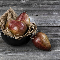Buy canvas prints of Raw pears inside and outside of bowl on aged wooden table in clo by Thomas Baker