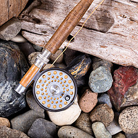 Buy canvas prints of Vintage fly fishing outfit on rocks and wood backg by Thomas Baker
