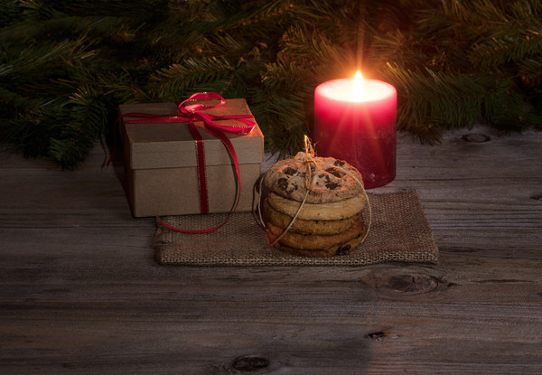 Neatly tied fresh cookies with warm glowing candle Picture Board by Thomas Baker