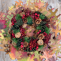 Buy canvas prints of Autumn cone wreath and leaves on rustic wooden boa by Thomas Baker