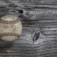 Buy canvas prints of Single used baseball on vintage wooden background. by Thomas Baker