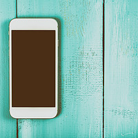 Buy canvas prints of White Mobile Phone With Blank Screen On Wood Table by Radu Bercan