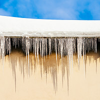 Buy canvas prints of House Roof Covered In Snow And Dangerous Icicles by Radu Bercan
