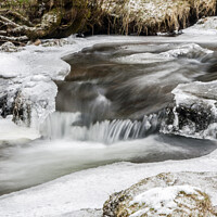 Buy canvas prints of A flowing stream under snowy conditions  by Nick Jenkins
