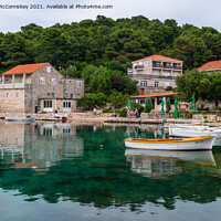 Buy canvas prints of Colourful reflections in Pomena harbour, Croatia by Angus McComiskey