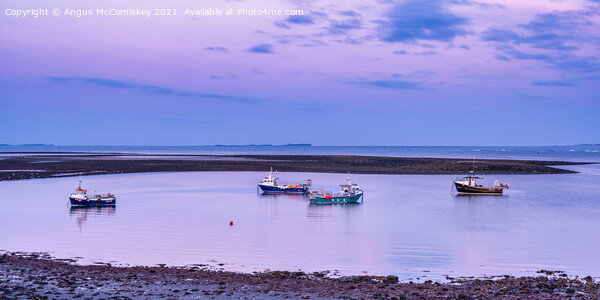 Fishing boats anchored at low tide, Holy Island Framed Mounted Print by Angus McComiskey
