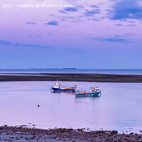 Buy canvas prints of Fishing boats anchored at low tide, Holy Island by Angus McComiskey