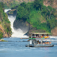 Buy canvas prints of Tourist boat in front of Murchison Falls in Uganda by Angus McComiskey