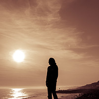 Buy canvas prints of Silhouetted girl stands by sea at sunset by George Cairns