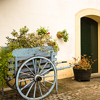 Buy canvas prints of Old fashioned cart for horse with flowers by old white wall by Steve Heap