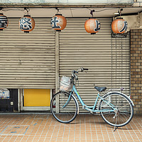 Buy canvas prints of A single bicycle outside a closed shop in Tokyo by Gary Parker