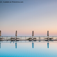 Buy canvas prints of row of sunbeds and sun shades, reflecting in a still swimming pool, as the sun sets, in the Mediterranean	 by Gary Parker