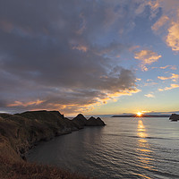 Buy canvas prints of JoEvansPurple clouds over Three Cliffs Bay by Jo Evans