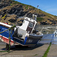 Buy canvas prints of A fishing boat anchored in Port Isaac bay by Joy Walker