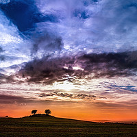 Buy canvas prints of Colourful cloudy sky sunset behind a small hill by André Jorge